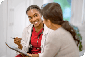 A provider softly smiles as they speak to a patient