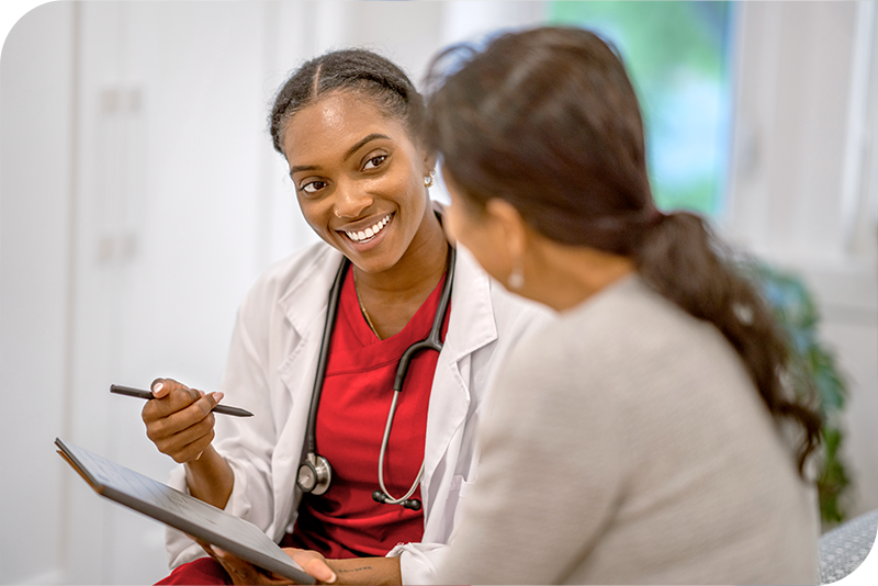 A provider softly smiles as they speak to a patient