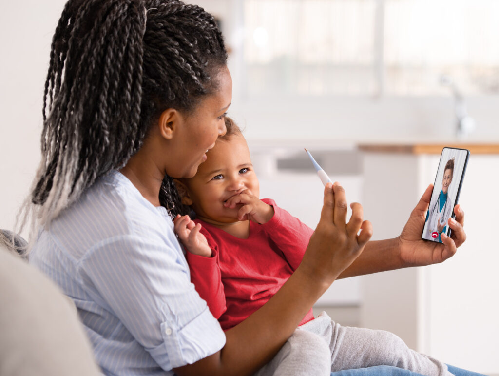 Photo of mom with child having an online appointment with her doctor