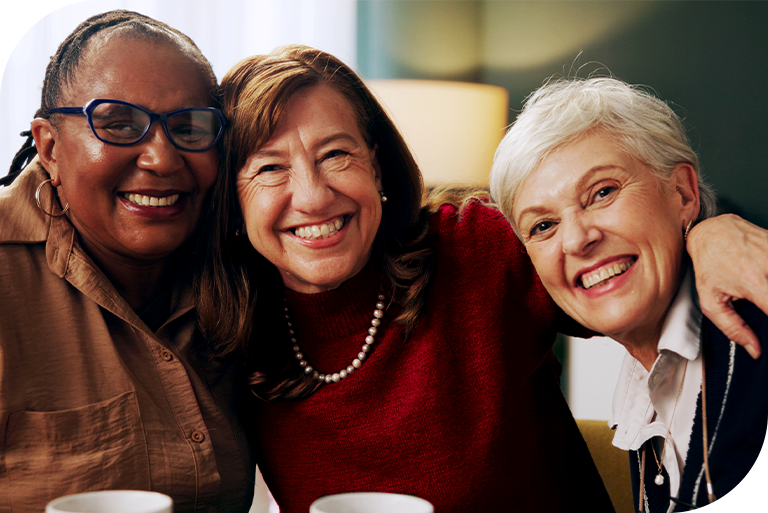 Three senior women hugging