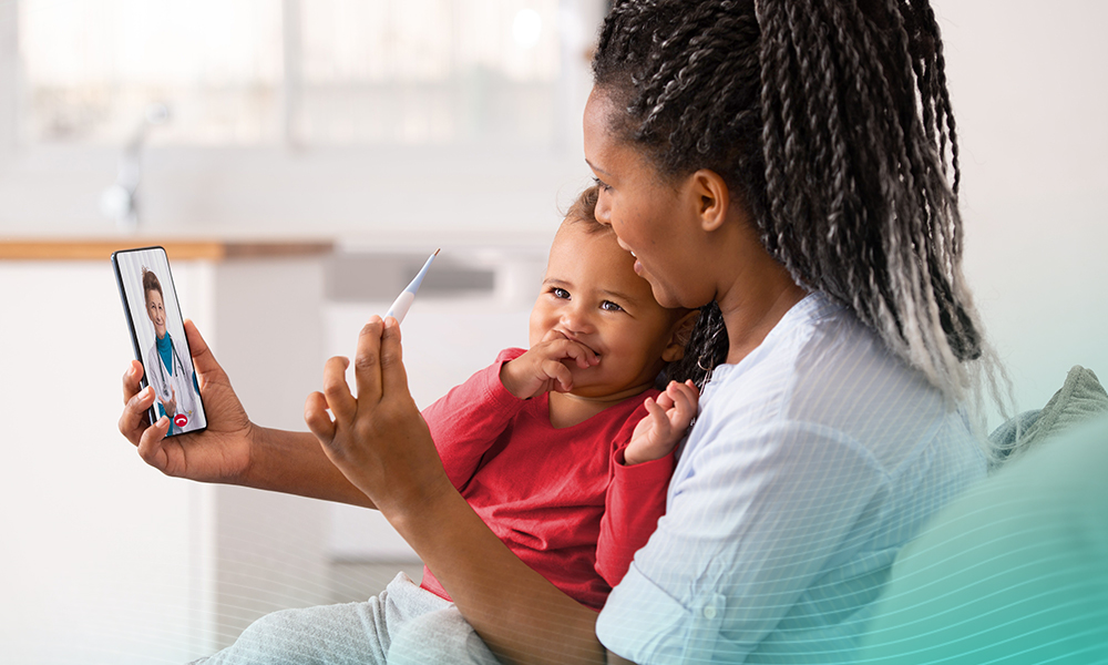 Woman and baby daughter using a smartphone to communicate with the doctor, showing thermometer display to her.