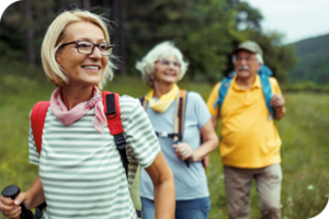 Group of people with walking sticks on a hike through the woods.