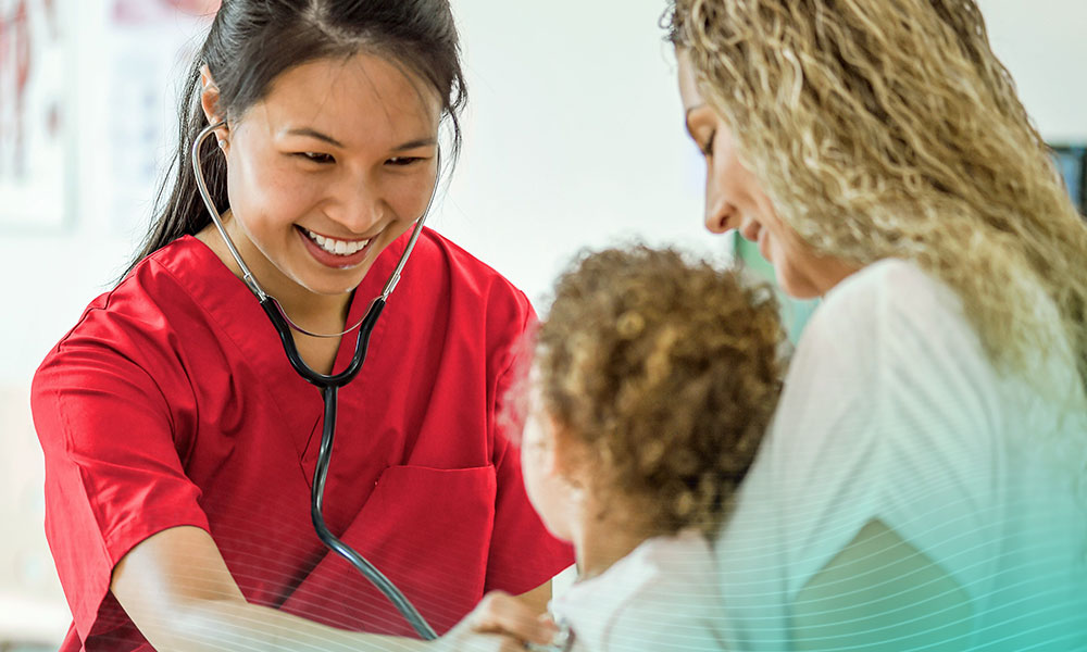 A little girl is with her mom at a check up appointment at the doctors office. A nurse is listening to the little girls heartbeat.