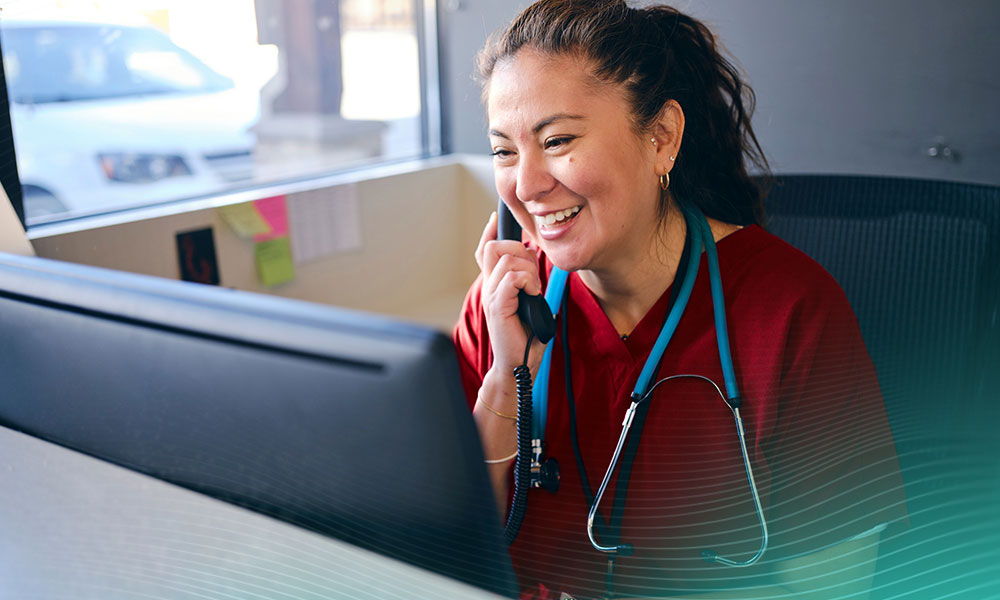 A healthcare working at a reception desk in an office.