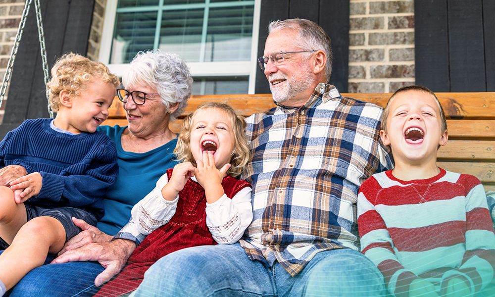 A beautiful family shot with grandparents and their grandchildren sitting on the home porch swing