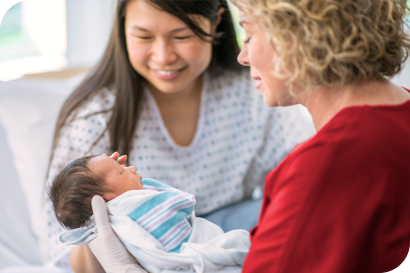 A doctor and a mother holding a newborn child.