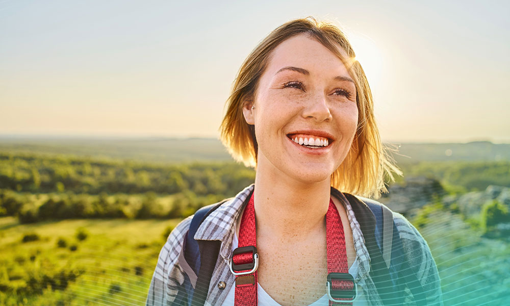 Portrait of a smiling woman hiking with backpack during summer holiday